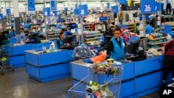Cashiers process purchases at a Walmart Supercenter in North Bergen, New Jersey, Feb. 9, 2023.