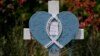 Construyen grandes cruces en un memorial improvisado cerca del centro comercial donde varias personas fueron asesinadas hace varios días, el lunes 8 de mayo de 2023, en Allen, Texas.
