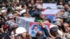 2024年5月23日，在伊朗马什哈德市举行的葬礼上，人们抬着覆盖着国旗的莱希总统及其同机人员的灵柩。（美联社照片）