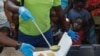 FILE - A server ladles soup as children line up to receive food at a shelter for families displaced by gang violence, in Port-au-Prince, Haiti, March 14, 2024.