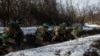 Ukrainian servicemen take cover during a shelling outside the frontline town of Bakhmut, amid Russia's attack on Ukraine, in Donetsk region, Ukraine, Feb. 13, 2023. 
