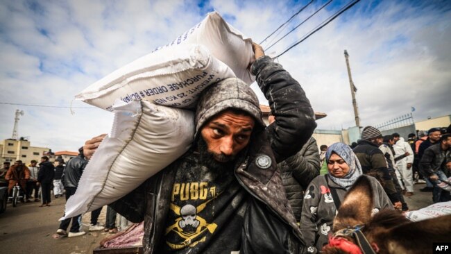 Displaced Palestinians receive food aid at the United Nations Relief and Works Agency for Palestine Refugees (UNRWA) center in Rafah in the southern Gaza Strip, Jan. 28, 2024.