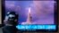 A man watches a TV screen showing footage of North Korea launching a missile from a submarine, during a news program at Seoul Railway Station in Seoul, South Korea, Oct. 20, 2021.