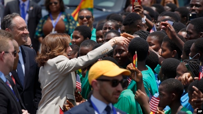 U.S. Vice President Kamala Harris greets school children during her arrival ceremony at Kotoka International Airport in Accra, Ghana, March 26, 2023.