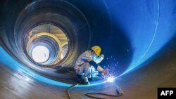 中國江蘇連雲港一家工廠的工人在焊接一個風井。（2023年5月31日）