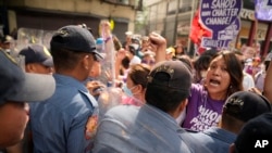 A protester shouts at police near the Malacanang presidential palace in Manila, Philippines, as demonstrators mark International Women's Day on March 8, 2023.