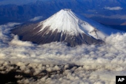 Gunung Fuji, puncak tertinggi di Jepang dengan ketinggian 3.776 meter, terlihat dari jendela pesawat, 8 Desember 2010. (Foto: AP)