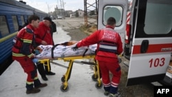 FILE - Medical workers transfer a wounded civilian patient from a train to an ambulance upon his arrival from the east of Ukraine in the western Ukrainian city of Lviv on March 22, 2023.