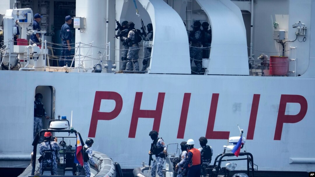 Personel penjaga laut Filipina berjaga di atas kapal PCG Melchora Aquino saat latihan Coast Guard di perairan Bataan, Filipina, Selasa, 6 Juni 2023. (Foto: AP)