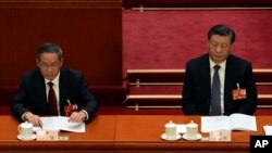 中国领导人习近平和李强在北京人大会堂出席全国人大会议。（2023年3月7日）