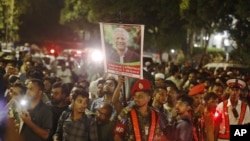 A crowd gathers in front of the president's official residence during the oath-taking ceremony of the interim government, led by Nobel laureate Muhammad Yunus, in Dhaka, Bangladesh, Aug. 8, 2024.