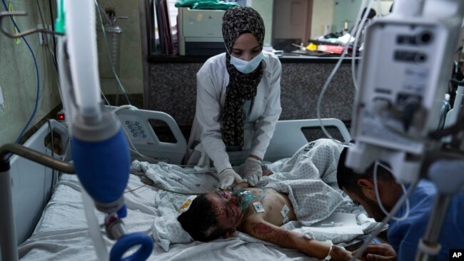 A Palestinian boy wounded during an Israeli airstrike receives medical treatment at Nasser Hospital in Khan Younis, Gaza Strip, Sunday, Oct. 15, 2023. (AP Photo/Fatima Shbair)