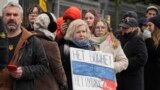 Россияне стоят в очереди у посольства России в Варшаве, Польша, в воскресенье, 17 марта 2024 года c плакатом против войны и против Путина (AP Photo/Czarek Sokolowski) 