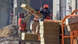 FILE - Laborers work at a housing construction site of Granelle, a Moscow-based developer, in southwest Moscow, Russia, March 12, 2021.