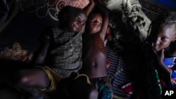 Children rest in a hut on the side of the road crowded with some 140 people in Niamey, Niger, July 31, 2023. 