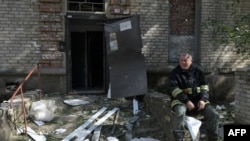 Сотрудник службы спасения рядом с жилым домом, поврежденным в результате ракетного обстрела в Луганске, на украинской территории, оккупированной Россией. 7 июня 2024 года. (Photo by STRINGER / AFP)