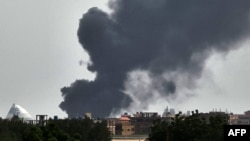 Smoke billows behind buildings from a reported fire in Khartoum, June 5, 2023, as fighting continues between two warring generals. 