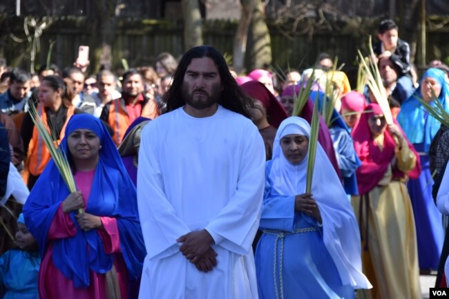 Un feligrés interpreta el papel de Jesús el Nazareno en la procesión del Domingo de Ramos el 2 de abril en las calles aledañas a la iglesia de San Antonio de Padua en Falls Church, Virginia. [Foto: Tomás Guevara, VOA]