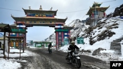 In this picture taken on April 5, 2023, motorbike riders cross into the snow laden Himalayan Sela pass in Tawang in northeast Indian state of Arunachal Pradesh.
