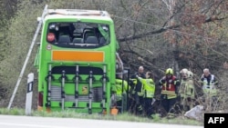 Police officers and emergency personnel react next to a damaged bus on the A9 highway, at the scene of an accident where at least five people were killed, on March 27, 2024 in Schkeuditz, near Leipzig, eastern Germany.