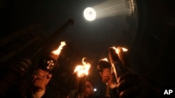 Christians hold candles during the Holy Fire ceremony, a day before Easter, at the Church of the Holy Sepulcher in Jerusalem's Old City, April 15, 2023.