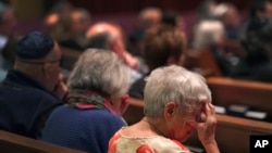 Anne Faigen, right, says a silent prayer for her friends in Israel while at a Shabbat service at Temple Sinai in Pittsburgh, Pennsylvania, Oct. 13, 2023.