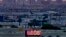 FILE - A sign displays an unofficial temperature as jets taxi at Sky Harbor International Airport at dusk, July 12, 2023, in Phoenix. 