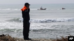 An Italian Coast Guard officer stands on a beach near Cutro, southern Italy, Feb. 28, 2023.