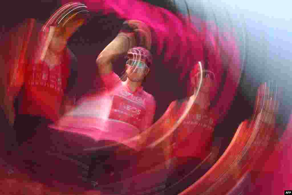 A photo with a long exposure and a movement effect shows overall leader INEOS Grenadiers's British rider Geraint Thomas waving onstage prior to the 19th stage of the Giro d'Italia 2023 cycling race, 183 km between Longarone and Tre Cime di Lavaredo.