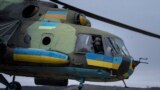 A Ukrainian pilot waves to his comrades from an Mi-8 combat helicopter during a combat mission in Donetsk region, Ukraine, March 18, 2023. 