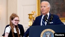 Presiden AS Joe Biden memegang tangan Miriam Butorin, putri dari jurnalis AS yang baru dibebaskan dari Rusia, Alsu Kurmasheva, di Gedung Putih, Washington, pada 1 Agustus 2024. (Foto: Reuters/Nathan Howard)