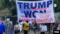 Decenas de manifestantes se reunieron en las cercanías de la cárcel del condado de Fulton, en Atlanta, Georgia, el 24 de agosto de 2023 para expresar sus opiniones sobre el expresidente de EEUU, Donald Trump, con banderas donde se lee "Trump ganó" y "Trump arrestado", en inglés. 