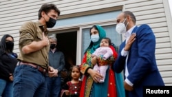 FILE - Canada's Prime Minister Justin Trudeau greets a family who recently resettled in Ottawa from Afghanistan, in Ottawa, Oct. 9, 2021. 