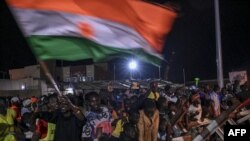 FILE - Supporters of Niger's National Concil for the Safeguard of the Homeland display a National flag as they protest ouside a French and Niger airbase in Niamey on Sept. 9, 2023 to demand the departure of the French army from Niger. 