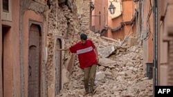 A resident walks carefully through rubble following a 6.8 magnitude quake in Marrakech, Morocco, Sept. 9, 2023.