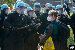 A protester confronts police during a demonstration at the Democratic National Convention, Aug. 19, 2024, in Chicago.