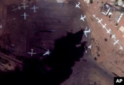 This satellite image provided by Maxar Technologies shows two burning planes at Khartoum International Airport, Sudan, Sunday April 16, 2023. (Satellite image ©2023 Maxar Technologies via AP)