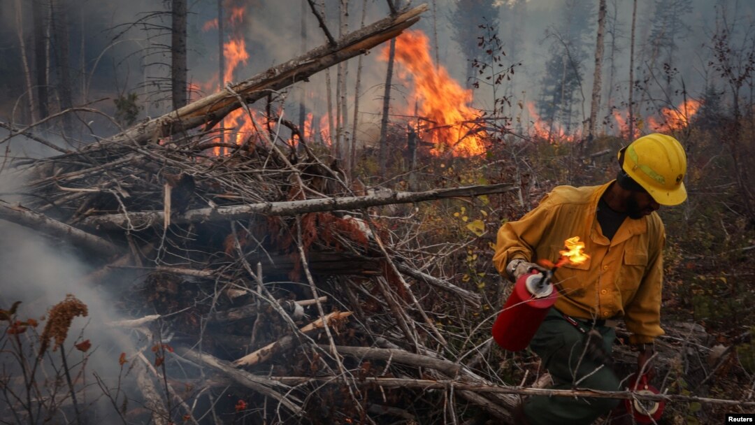FILE - Kenyatta Bridges, 34, an inmate and member of Arcadia 20, sets fire to a burn pile during prescribed fire operations on a deployment near Northport, Washington, Oct. 25, 2023.