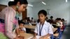 Seorang instruktur membantu siswa di madrasah modern berbahasa Inggris di Benggala Barat, India, 2 April 2024. (Shaikh Azizur Rahman/VOA)