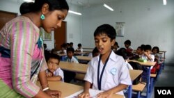 Seorang instruktur membantu siswa di madrasah modern berbahasa Inggris di Benggala Barat, India, 2 April 2024. (Shaikh Azizur Rahman/VOA)