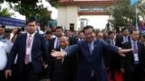 FILE - Prime Minister Hun Sen (center R) and President of the National Assembly Heng Samrin (center L) arrive before a ceremony at the party headquarters in Phnom Penh, January 7, 2017.