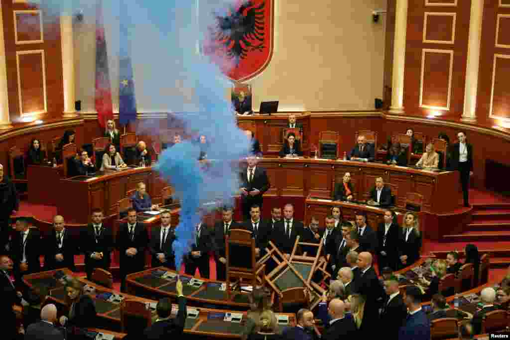 A member of parliament from the Democratic Party, Albania&#39;s biggest opposition party, sets off a smoke flare as the parliament gathers for a vote on whether to lift the immunity of opposition leader Sali Berisha so he can face corruption charges, in Tirana.