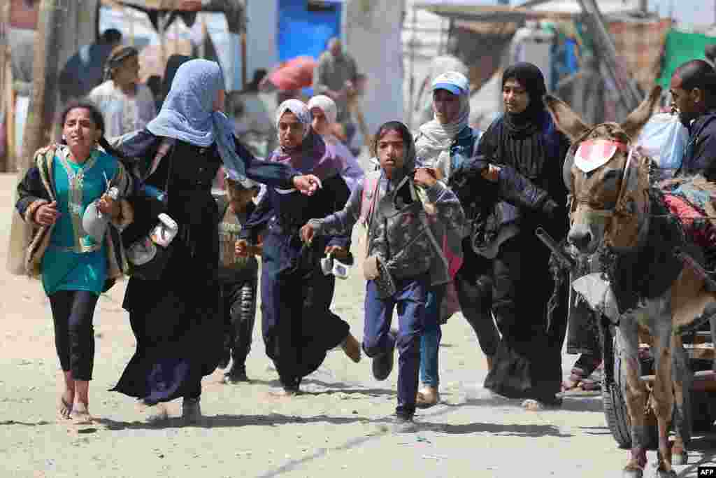 Palestinians rush during Israeli bombardment in the area in Rafah in the southern Gaza Strip.