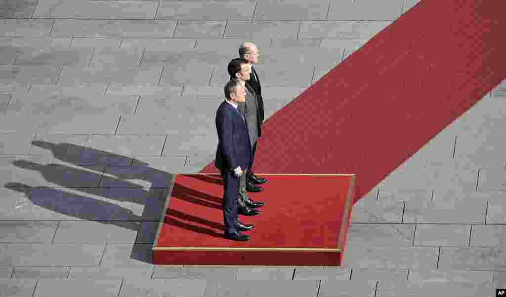 German Chancellor Olaf Scholz, French President Emmanuel Macron and Poland's Prime Minister Donald Tusk, from right, stand at a red carpet for military honors in Berlin, Germany.