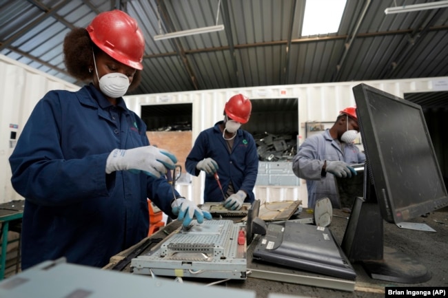 Employees dismantle laptop waste at WEEE center recycling plant, a collection point where people can deposit old electric equipment in Nairobi, Kenya Wednesday, March. 20, 2024. (AP Photo/Brian Inganga)