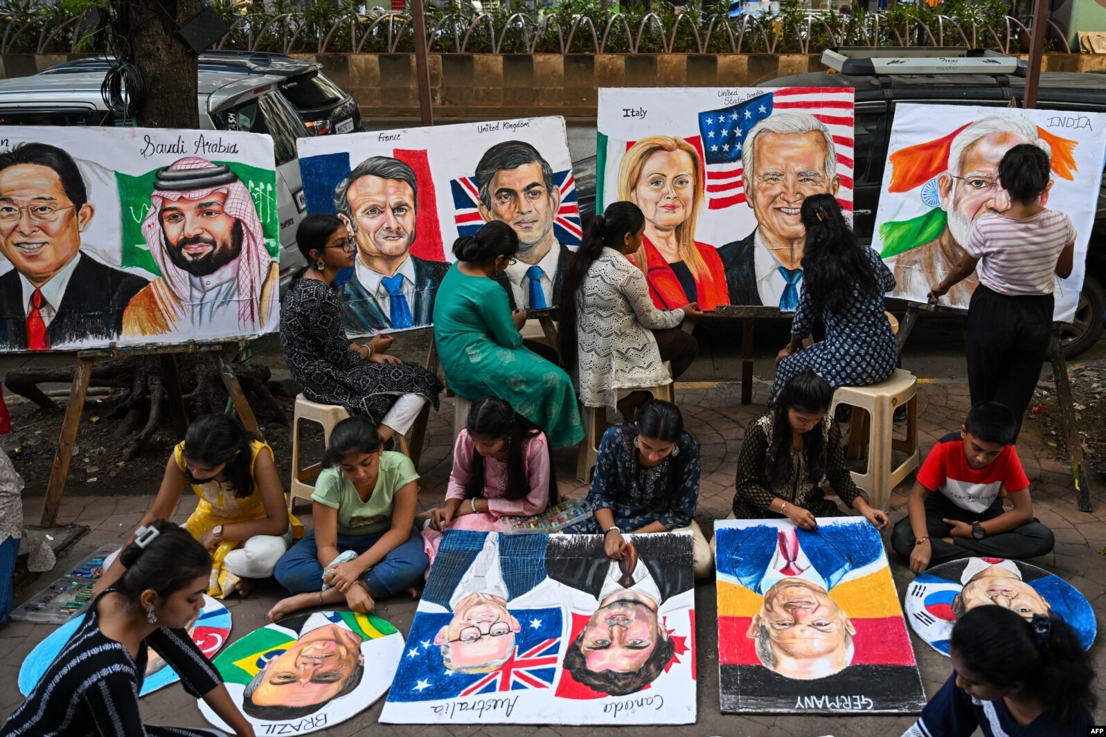 Para siswa sedang melukis para pemimpin dunia di sebuah sekolah seni di Mumbai pada 5 September 2023, menjelang KTT G20 di New Delhi. (Foto: AFP)