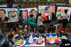 Para siswa sedang melukis para pemimpin dunia di sebuah sekolah seni di Mumbai pada 5 September 2023, menjelang KTT G20 di New Delhi. (Foto: AFP)