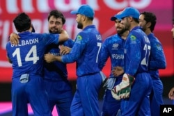Afghanistan players celebrate after defeating Bangladesh by eight runs in their men's T20 World Cup cricket match at Arnos Vale Ground, Kingstown, Saint Vincent and the Grenadines, June 24, 2024.
