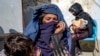 FILE - Mothers with malnourished babies wait for help at a World Food Program clinic in Kabul, Afghanistan, Jan. 26, 2023. A Taliban edict banning women from working at national and international NGOs has severely impacted such people.