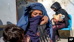 FILE - Mothers with malnourished babies wait for help at a World Food Program clinic in Kabul, Afghanistan, Jan. 26, 2023. A Taliban edict banning women from working at national and international NGOs has severely impacted such people.